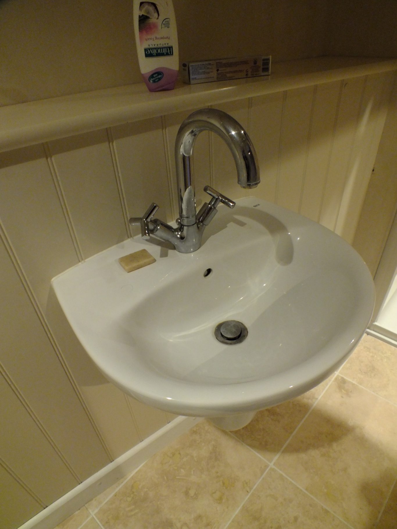 Original sink 2 A white sink with a silver tap in a bathroom setting.