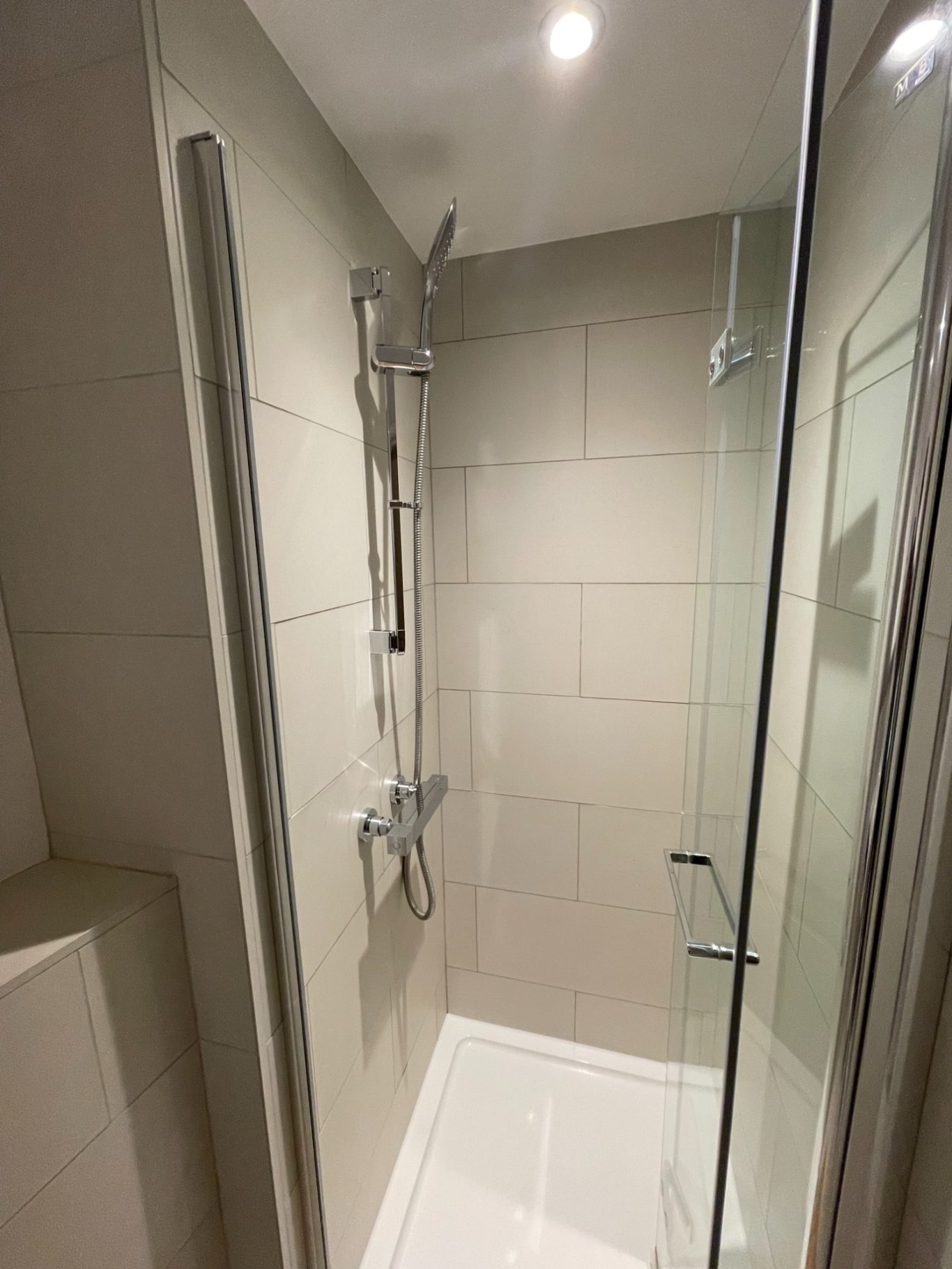 Shower Enclosure Modern shower enclosure with grey tiles and dual shower heads.