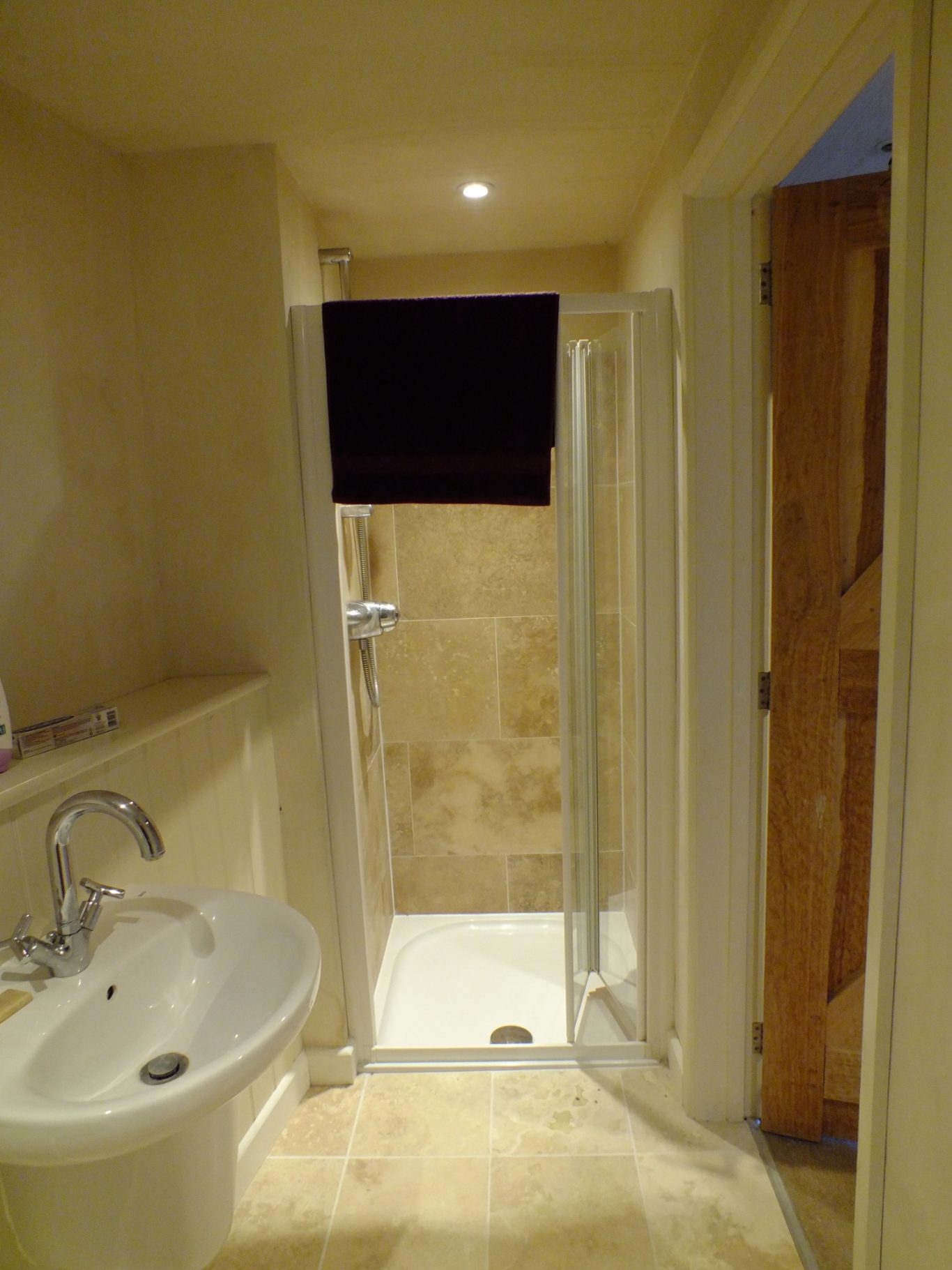Old shower enclosure Bathroom interior featuring a sink and a walk-in shower with glass door.