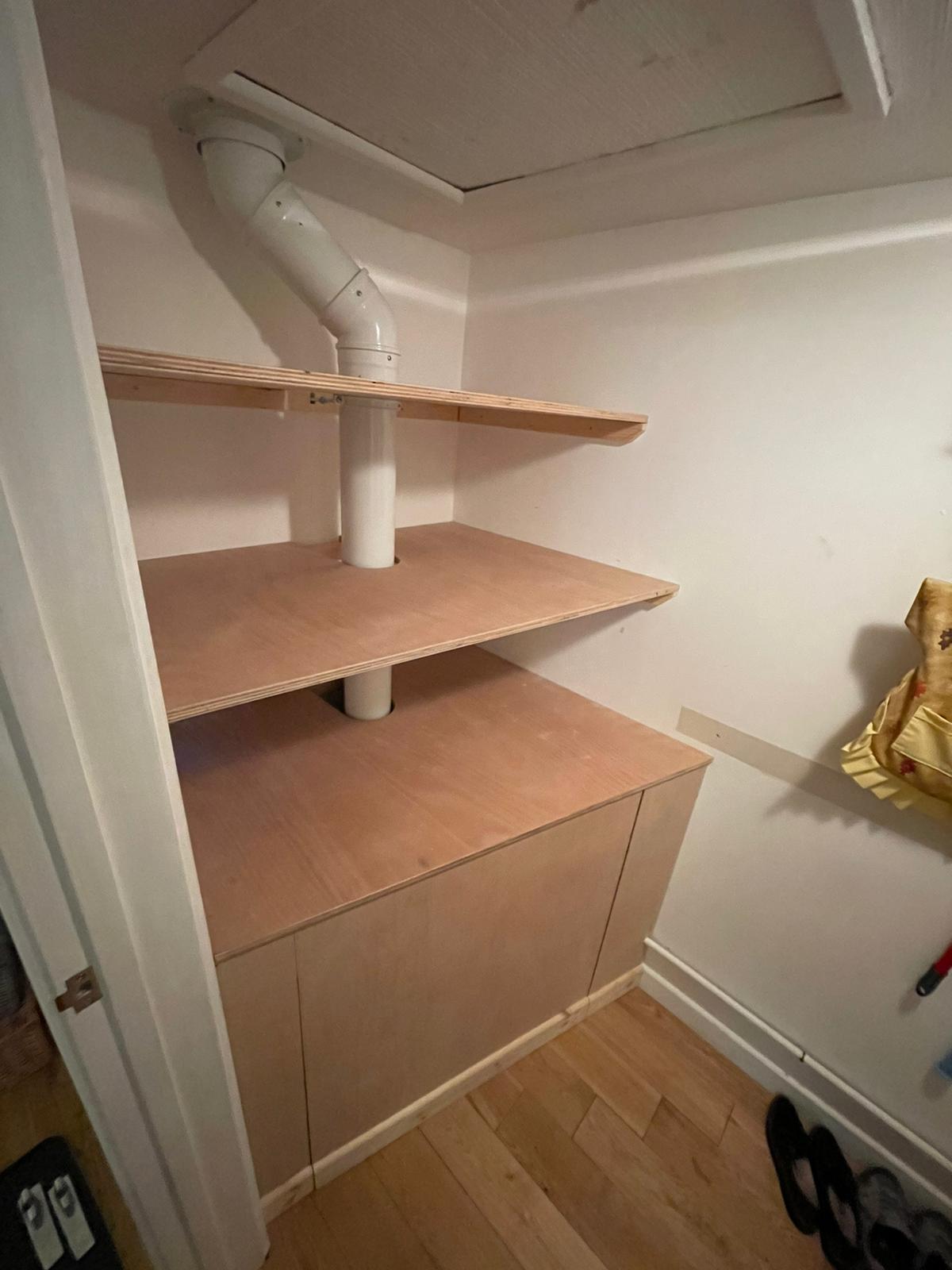 New boiler boxing in Small storage space with two shelves and a cabinet below, featuring a white pipe.